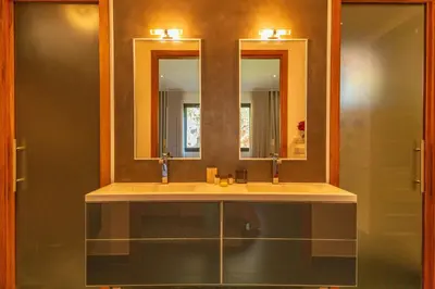 a bathroom with a sink and two mirrors at Casa Carolina Di Palombaggia in Porto-Vecchio