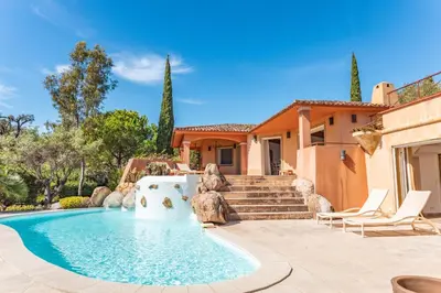a home with a swimming pool and a house at Villa Domaine de Pinarello in Pinarellu