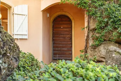 a brown door on a house with a window at Villa Domaine de Pinarello in Pinarellu