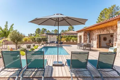 a patio with chairs and an umbrella next to a pool at Villa Felicita di Lecci in Lecci