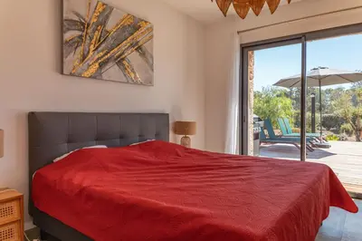 a bedroom with a red bed and a sliding glass door at Villa Felicita di Lecci in Lecci