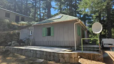 a small house with a porch and a satellite at CHALET BAVEDDA- Accès chemins de randonnée- Calme - Montagne in Quenza