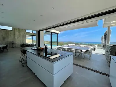an open kitchen with a view of the ocean at Villa contemporaine ORIZONTE - 15 pers - 400m2 vue mer in Zonza
