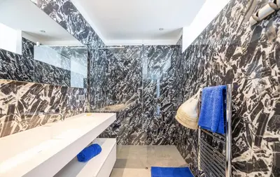 a bathroom with a black and white tiled wall at Villa contemporaine ORIZONTE - 15 pers - 400m2 vue mer in Zonza