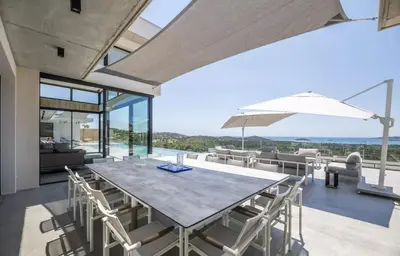 an open dining room with a table and chairs at Villa contemporaine ORIZONTE - 15 pers - 400m2 vue mer in Zonza