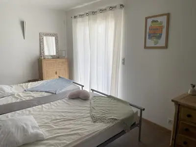 a bedroom with a bed with a window and a dresser at House with sea view, Route de Palombaggia in Porto-Vecchio