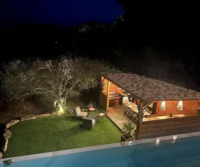 a backyard with a deck and a pavilion at night at House with sea view, Route de Palombaggia in Porto-Vecchio