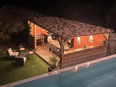 a gazebo next to a swimming pool at night at House with sea view, Route de Palombaggia in Porto-Vecchio