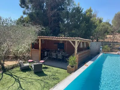 a backyard with a pool and a pergola next to a house at House with sea view, Route de Palombaggia in Porto-Vecchio