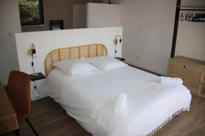 a bedroom with a bed with white sheets and pillows at House with sea view, Route de Palombaggia in Porto-Vecchio