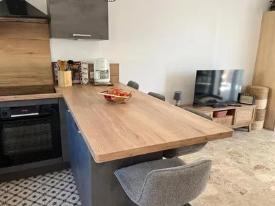 a kitchen with a wooden table with a bowl of fruit on it at Maison 30 mètres de la plage in Serra-di-Ferro
