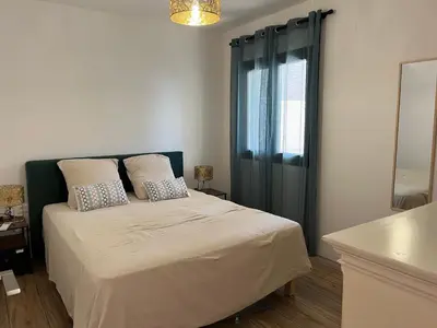 a bedroom with a large bed with a window at Maison 30 mètres de la plage in Serra-di-Ferro