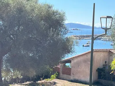 a house with a basketball hoop in front of the water at Maison 30 mètres de la plage in Serra-di-Ferro