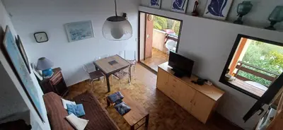 an overhead view of a living room with a television and a table at Duplex bord de mer avec jardin in Serra-di-Ferro