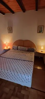 a bed in a bedroom with two lamps on tables at Duplex bord de mer avec jardin in Serra-di-Ferro