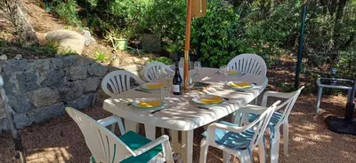 a white table with white chairs and a table with food at Duplex bord de mer avec jardin in Serra-di-Ferro