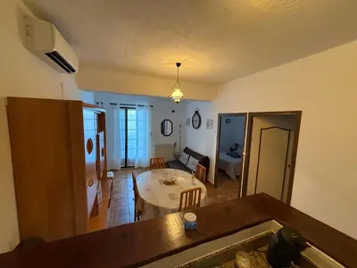 a kitchen and living room with a table and a dining room at chez Ange et Maryse à Olmeta di tuda in Olmeta-di-Tuda