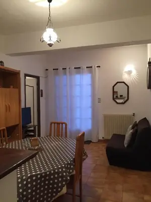 a living room with a dining table and a couch at chez Ange et Maryse à Olmeta di tuda in Olmeta-di-Tuda