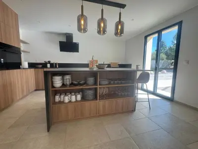 a kitchen with a counter with plates and bowls at Superbe Villa Arià avec piscine chauffée in Calenzana