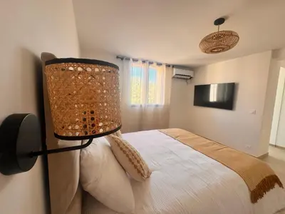 a bedroom with a bed with a lamp on the wall at Superbe Villa Arià avec piscine chauffée in Calenzana