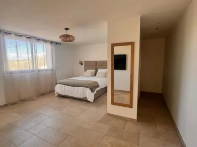 a bedroom with a bed and a mirror in it at Superbe Villa Arià avec piscine chauffée in Calenzana