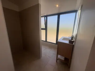 a bathroom with a sink and a large window at Superbe Villa Arià avec piscine chauffée in Calenzana