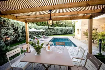 a patio with a table and chairs and a pool at La Prairie in Porto-Vecchio
