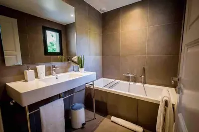 a bathroom with a sink and a tub and a mirror at La Prairie in Porto-Vecchio