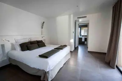 a large white bedroom with a large white bed at La Prairie in Porto-Vecchio