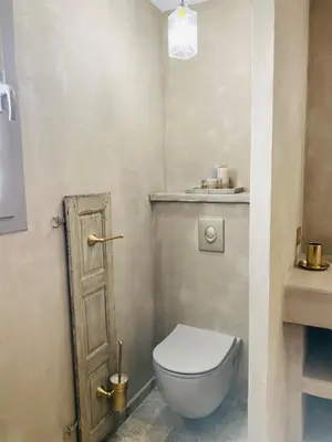 a bathroom with a toilet and a wooden door at U Casellu in Oletta
