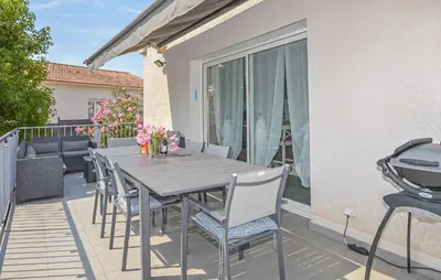 a wooden table and chairs on a deck with a balcony at Villa Moderne Plage À Pieds in Prunete