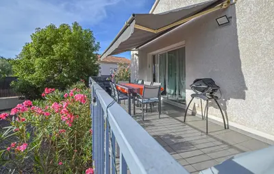 a balcony with a table and chairs and flowers at Villa Moderne Plage À Pieds in Prunete
