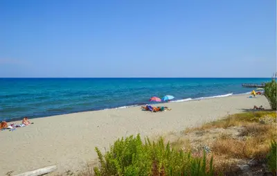 a group of people laying on a beach with umbrellas at Villa Moderne Plage À Pieds in Prunete