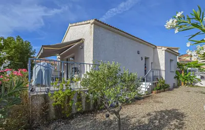 a small white house with a balcony and flowers at Villa Moderne Plage À Pieds in Prunete