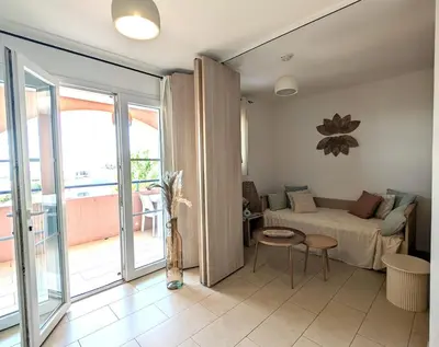 a living room with a bed and a balcony at Apartment at Solenzara Marina in Sari Solenzara