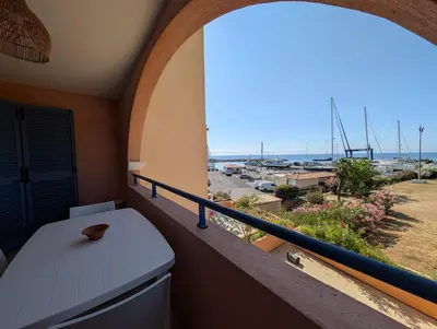 a balcony with a window with a view of a harbor at Apartment at Solenzara Marina in Sari Solenzara