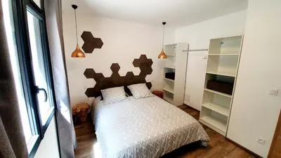 a bedroom with a bed in a room with a refrigerator at Appartement neuf avec extérieur de plein pieds in Levie