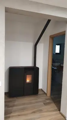 a living room with a fireplace in a room at Appartement neuf avec extérieur de plein pieds in Levie