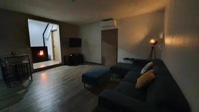 a living room with a couch and a table at Appartement neuf avec extérieur de plein pieds in Levie