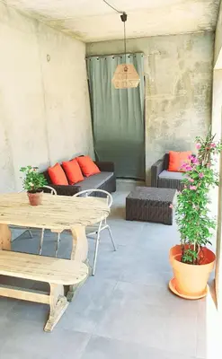 a patio with a table and chairs and a couch at Appartement neuf avec extérieur de plein pieds in Levie