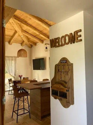 a dining room with a welcome sign on the wall at charmante bergerie in Bonifacio