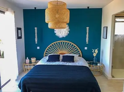 a bedroom with a bed with a blue wall at Villa With Views Over Gulf Of Ajaccio in Coti-Chiavari