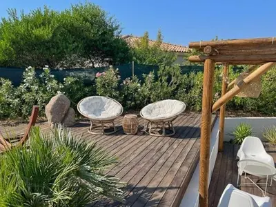 three tables and chairs on a wooden deck at Villa With Views Over Gulf Of Ajaccio in Coti-Chiavari