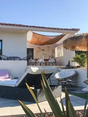 a house with a patio with tables and chairs at Villa With Views Over Gulf Of Ajaccio in Coti-Chiavari