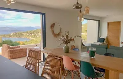 a dining room with a table and chairs and a large window at Villa With Views Over Gulf Of Ajaccio in Coti-Chiavari
