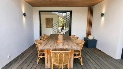 a wooden table and chairs on a wooden deck at Villa Juca, 10 pers, piscine chauffée, 10 minutes plage in Cirendinu