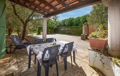 a patio with a table and chairs under a pergola at Stunning Home In Querciolo in Venzolasca
