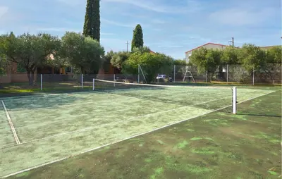 a tennis court with a net in a park at Stunning Home In Querciolo in Venzolasca