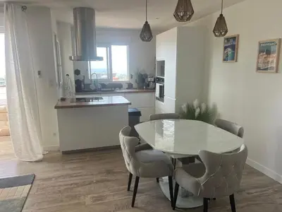 a kitchen with a table and chairs in a room at Bleu Corse, entre mer et soleil in Ajaccio