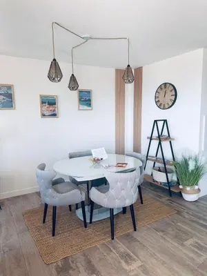 a dining room with a table and chairs and a clock at Bleu Corse, entre mer et soleil in Ajaccio